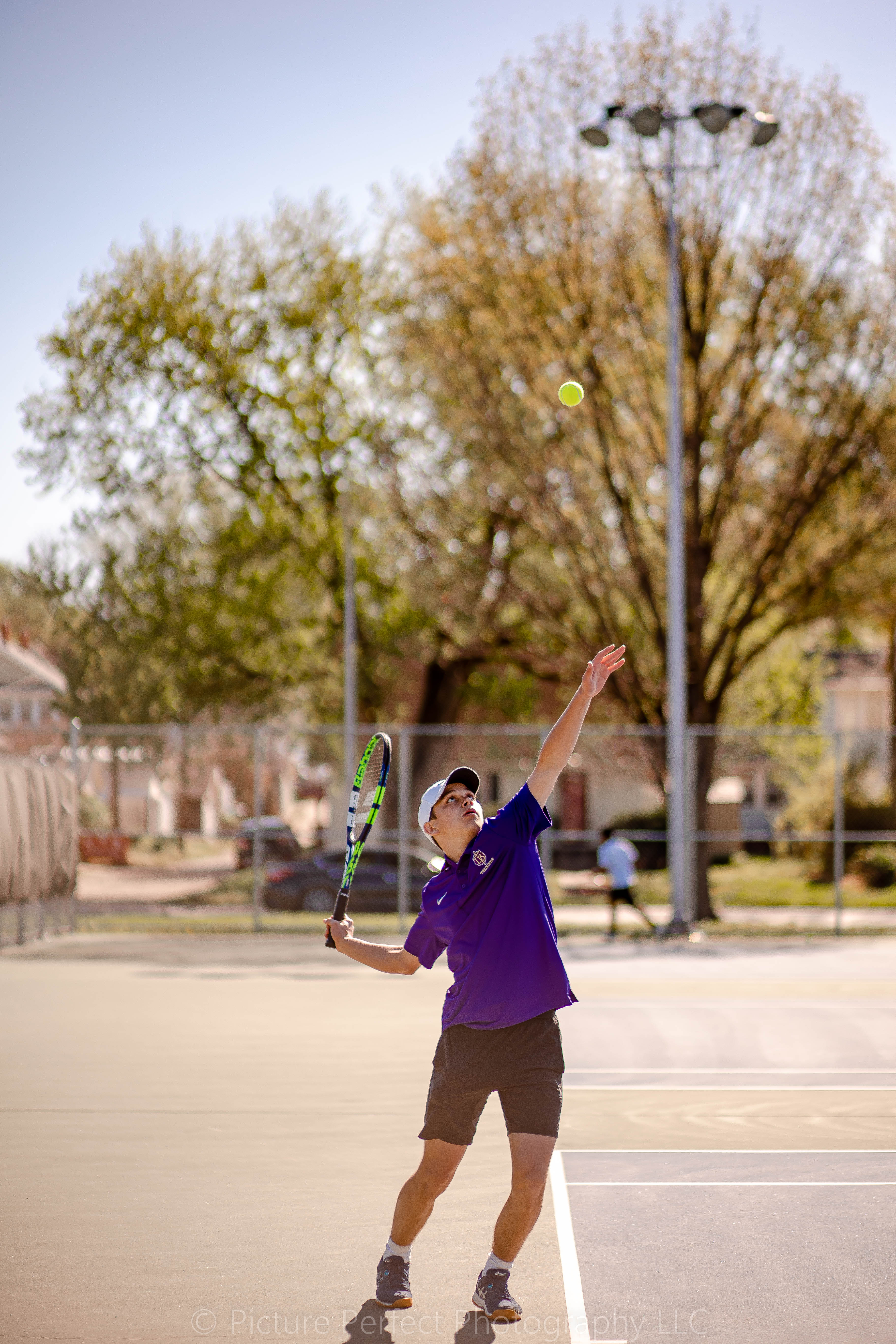 Picture of boy serving tennis ball